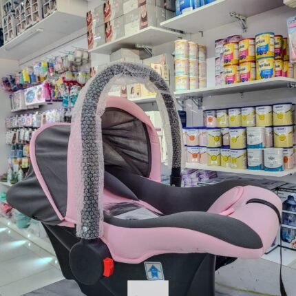 Pink and black baby carry cot with carry handle and sun canopy